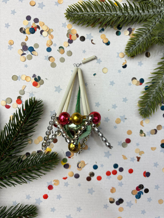 a festive scene with a Christmas ornament, confetti, and pine branches.