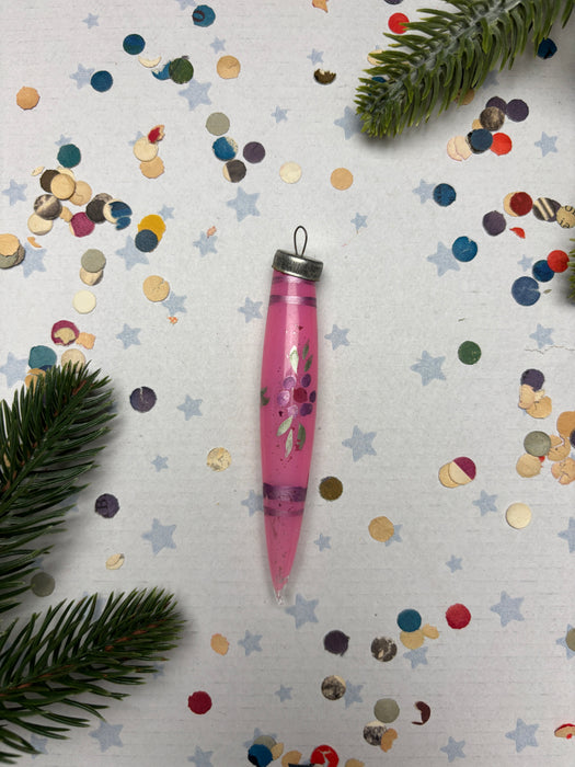 a pink pen with a floral design, surrounded by colorful confetti and pine branches.