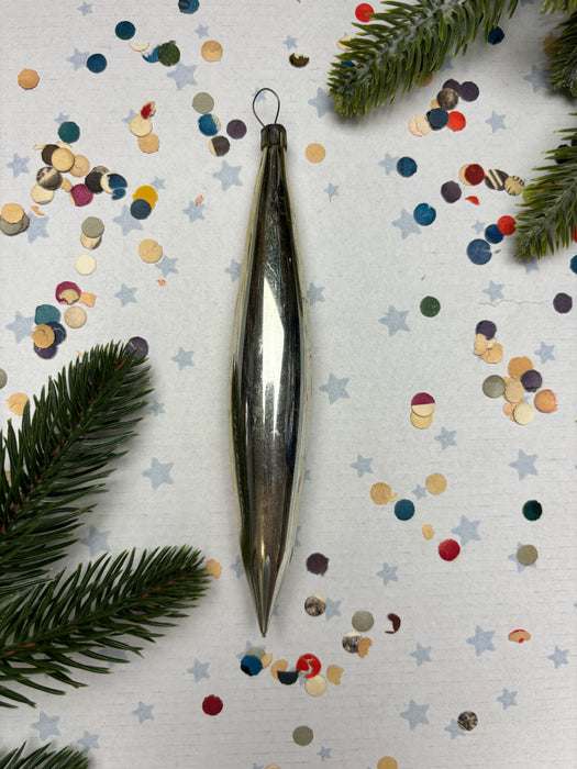 a shiny metallic ornament, a bunch of colorful confetti, and some pine branches, all arranged on a white background with scattered stars.