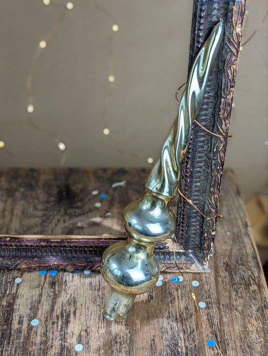 a decorative metal ornament with a twisted, metallic design, placed on a wooden surface.