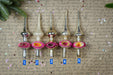 a collection of five ornamental objects, each with a unique design and color, arranged in a row on a textured surface. The objects are numbered 1 through 5, indicating their position in the row. The background of the image is filled with handwritten text, which appears to be a list or description of the objects.