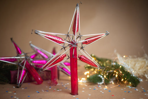 a star-shaped ornament with red and pink lights, surrounded by holiday decorations such as a Christmas tree and confetti.
