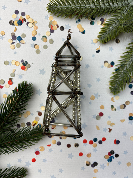 a metallic structure resembling a bridge, surrounded by a scattering of colorful confetti and pine branches.