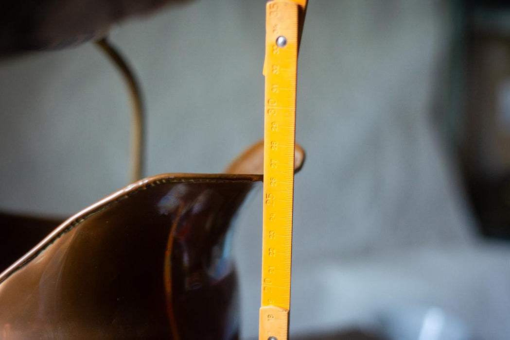 A close-up view of a metal object, possibly a ruler or measuring tool, with a yellow measuring scale on it. The object appears to be made of a shiny, metallic material and is positioned vertically.