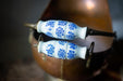 two blue and white floral-patterned handles on a copper-colored object, which appears to be a bowl or container.